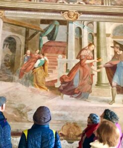 Group of people viewing an elaborate fresco within one of the chapels at Sacro Monte di Orta, Italy