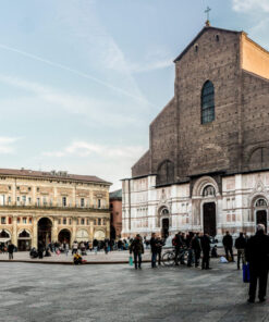 The main square of Bologna, Piazza Maggiore, with the unfinished facade of San Petronio Basilica and people walking